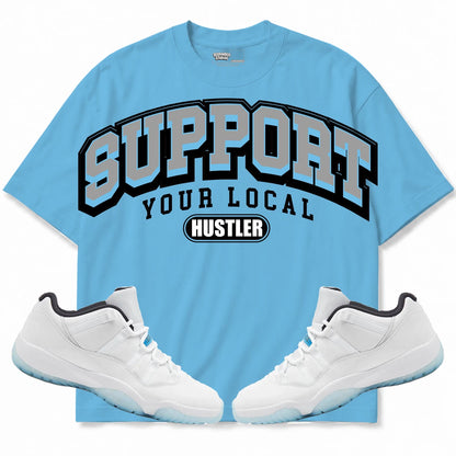Rebranded Studios Support Your Local Hustler Air Jordan 11 Legend Blue Collection light blue shirt — front with sneakers
