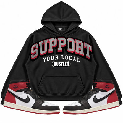 Rebranded Studios Support Your Local Hustler Air Jordan 1 High OG Black Toe Reimagined Black hoodie — front with sneakers
