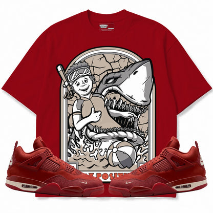 Rebranded Studios Stay Positive Air Jordan 4 Brick By Brick red shirt — front with sneakers