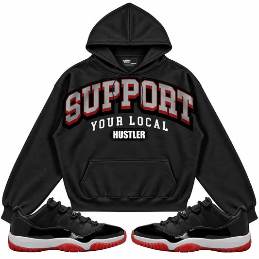 Rebranded Studios Support Your Local Hustler Air Jordan 11 Low Bred Black hoodie — front with sneakers